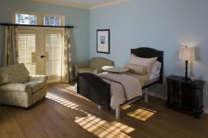 Patient suite at the Wayne T. Patrick Hospice House. The room is furnished with a patient bed, night stand, recliner, and sleeper sofa.